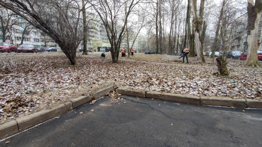 Уборка двора рабочими коммунальных служб в осенне-зимний период