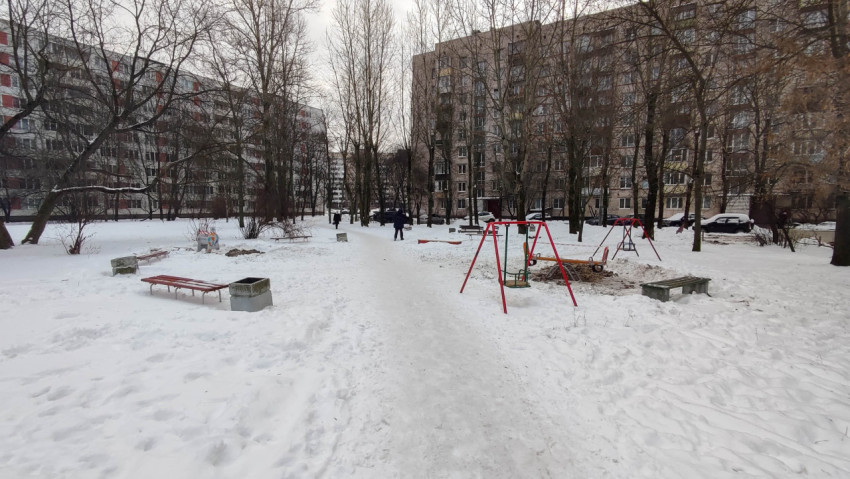 Зимняя детская площадка во дворе многоквартирного дома с недостроенными элементами