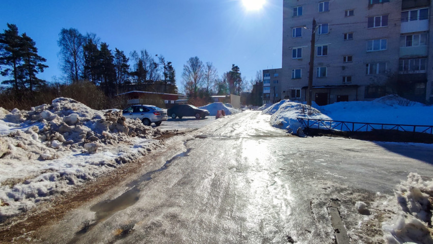 Зимняя дорога во дворе с обледенелым покрытием на солнце