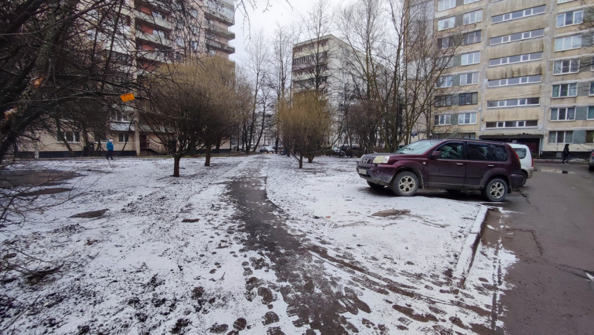 Заснеженная дворовая дорожка и припаркованные автомобили