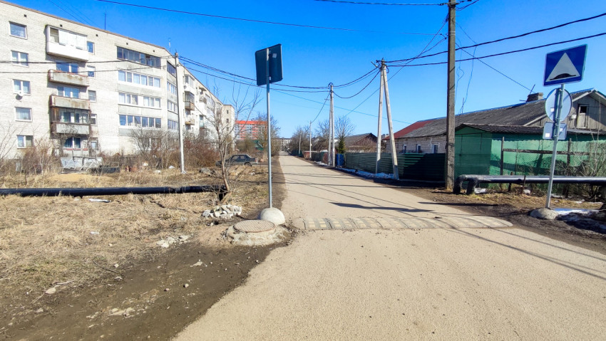 Дорога с лежачим полицейским и дорожными знаками у жилых домов