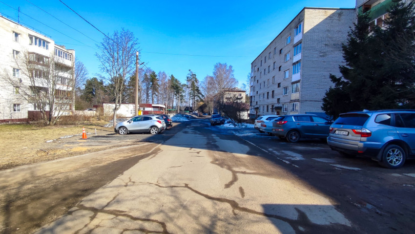 Дворовая дорога с припаркованными автомобилями весной