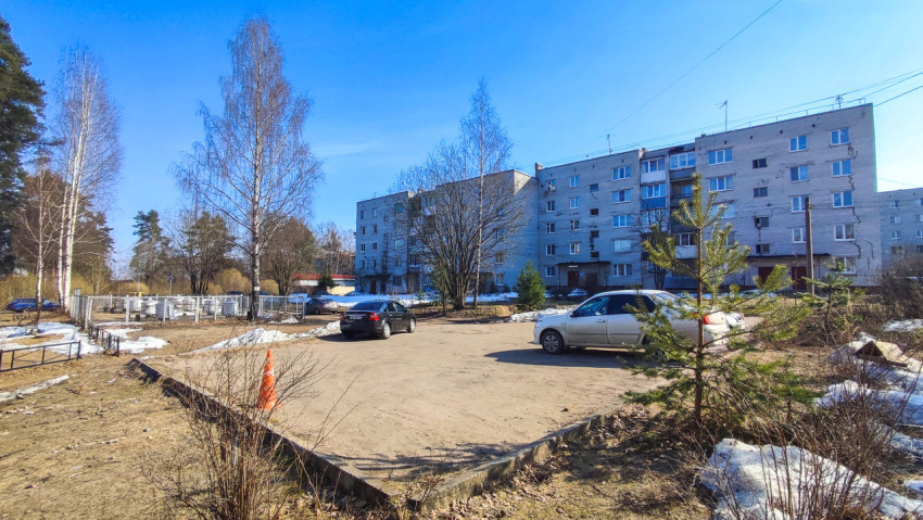 Площадка с припаркованными машинами между жилыми домами