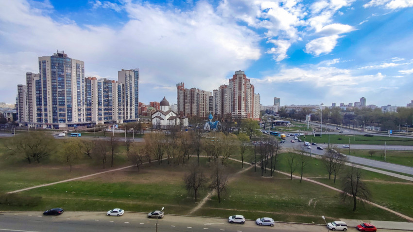 Городской пейзаж с высотками, храмом и уличным движением