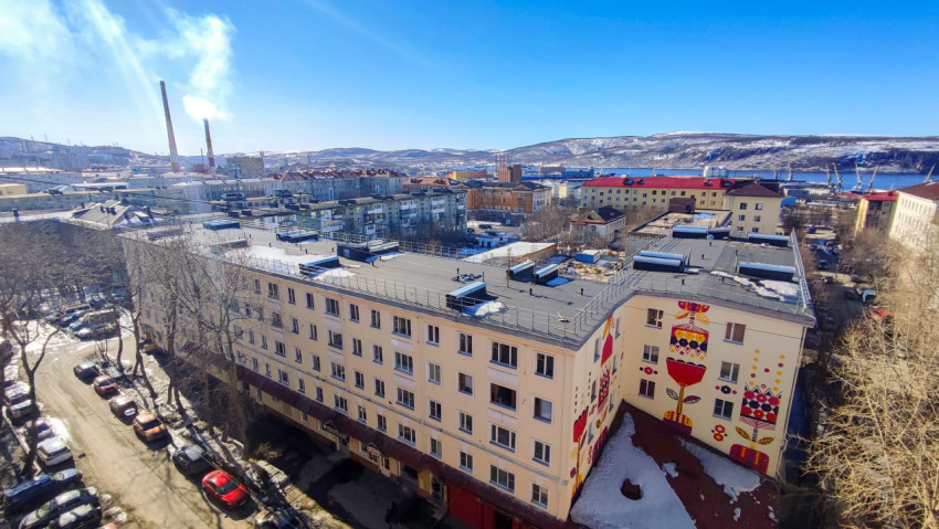 Городской квартал с домами и трубами ТЭЦ на фоне сопок