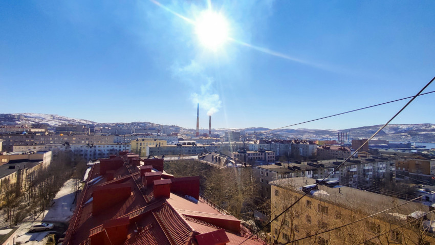 Панорама города с промышленными трубами и крышами зданий