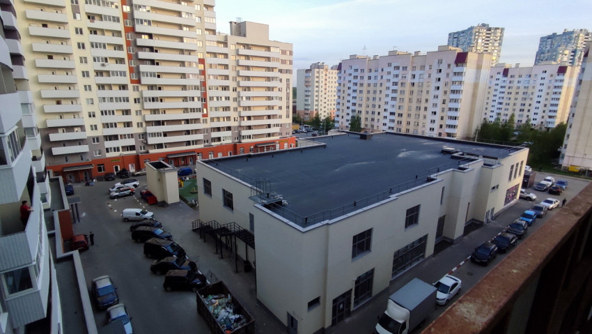 Двор жилого комплекса с многоэтажными домами и парковкой