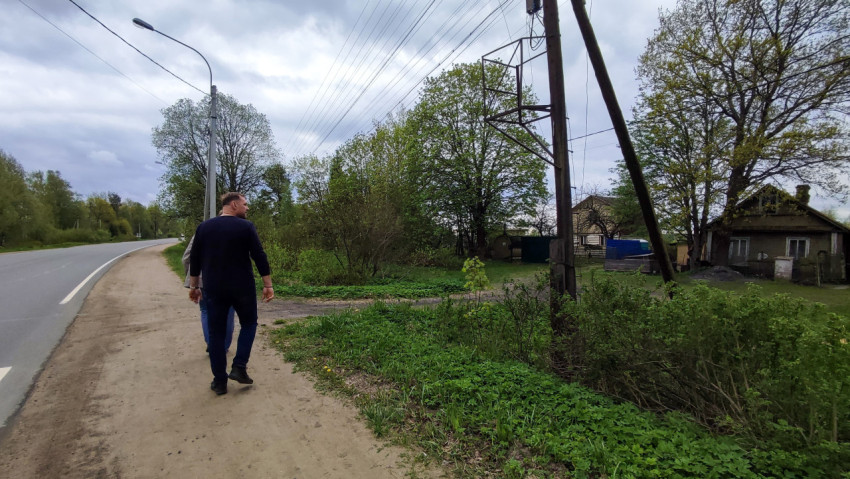 Мужчина на обочине дороги у старого деревянного дома