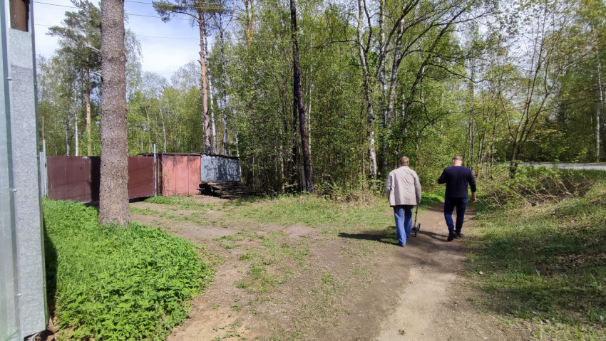 Грунтовая тропа у металлических ворот и контейнеров
