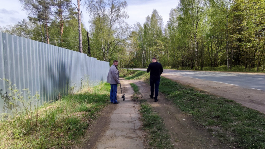 Пешеходы с измерительным колесом вдоль дороги