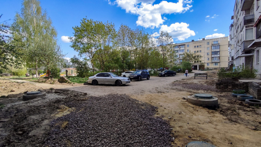 Двор жилого дома с парковкой и элементами благоустройства