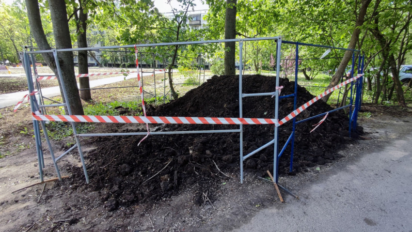 Складированная земля в ограждении во дворе жилого квартала