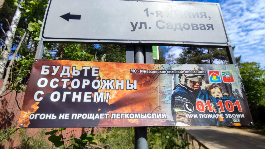 Баннер «Будьте осторожны с огнём» рядом с указателем улицы Садовая