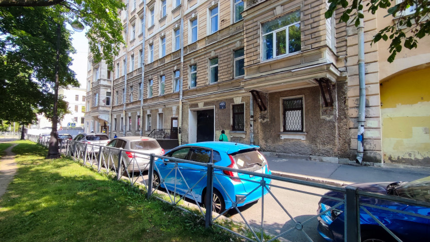 Улица с жилым домом и припаркованными машинами