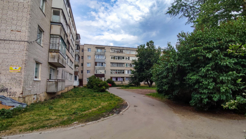 Жилой двор с многоквартирными домами и зелеными насаждениями