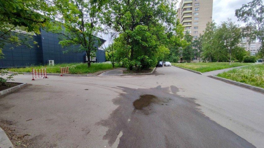 Дворовая дорога у здания с временными ограждениями