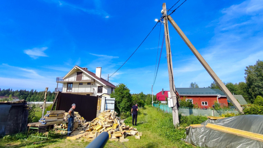 Деревянные заготовки у загородного дома и электропередач