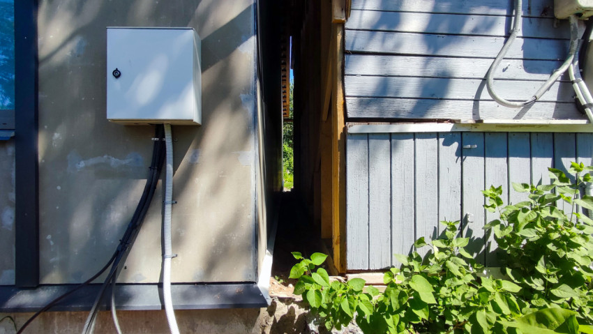 Узкий проход между двумя стенами с электрошкафом и обшивкой