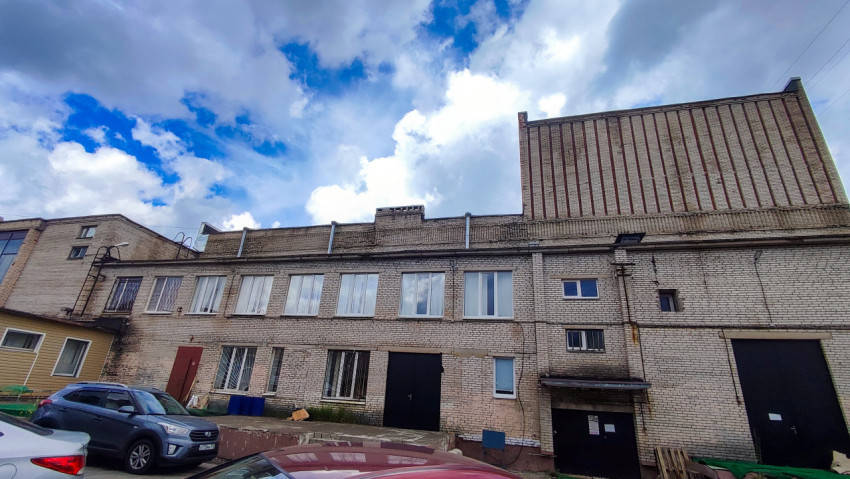 Фасад кирпичного здания с металлическими воротами и окнами