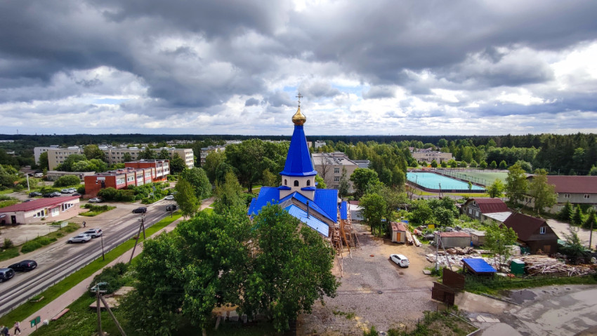 Вид на православный храм с синим шатром и жилую застройку