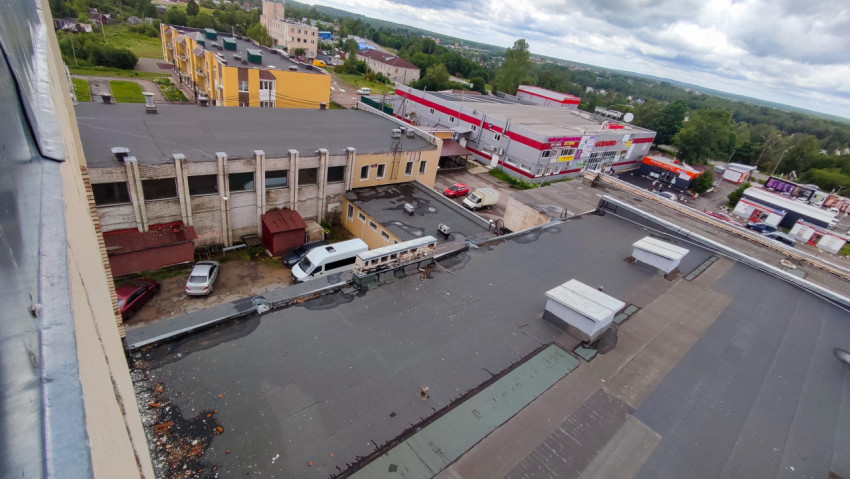 Вид на крыши зданий и прилегающий двор с парковкой
