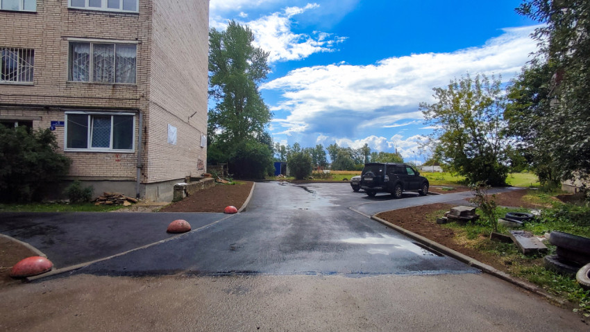 Асфальтированная придомовая территория с парковкой у жилого дома