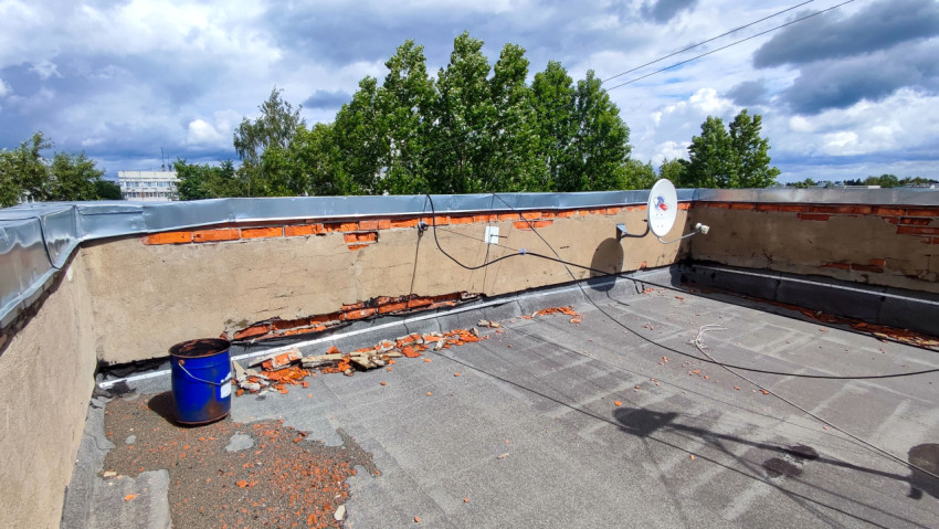 Крыша дома с поврежденной кладкой и спутниковой антенной