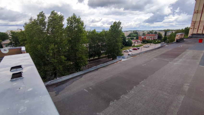 Плоская крыша здания с видом на жилой квартал и деревья
