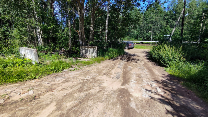 Автомобиль на грунтовой дороге возле леса и бетонных блоков