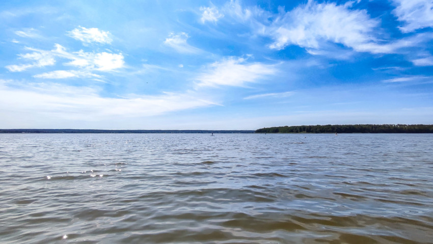 Озеро с отдыхающими людьми в солнечную погоду