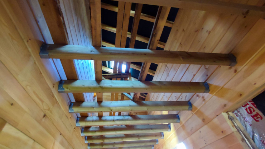 Деревянные балки потолка и стропильная система строящегося дома