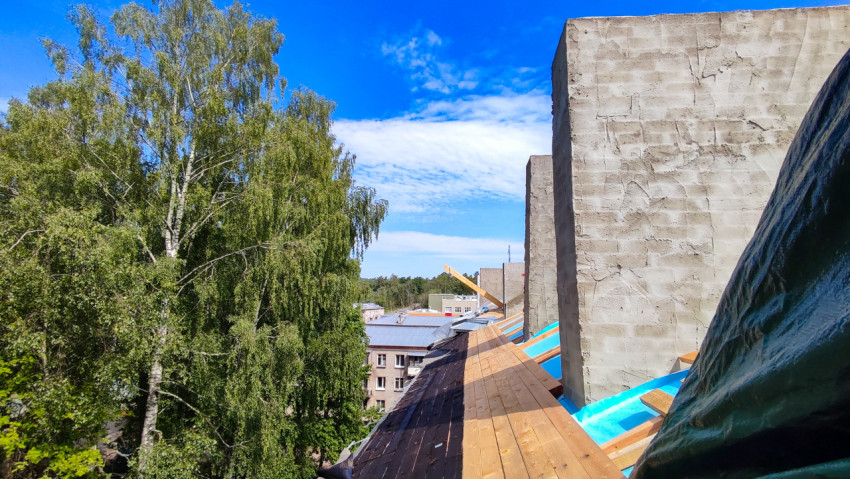 Крыша жилого здания с уложенной деревянной обрешёткой и гидроизоляцией