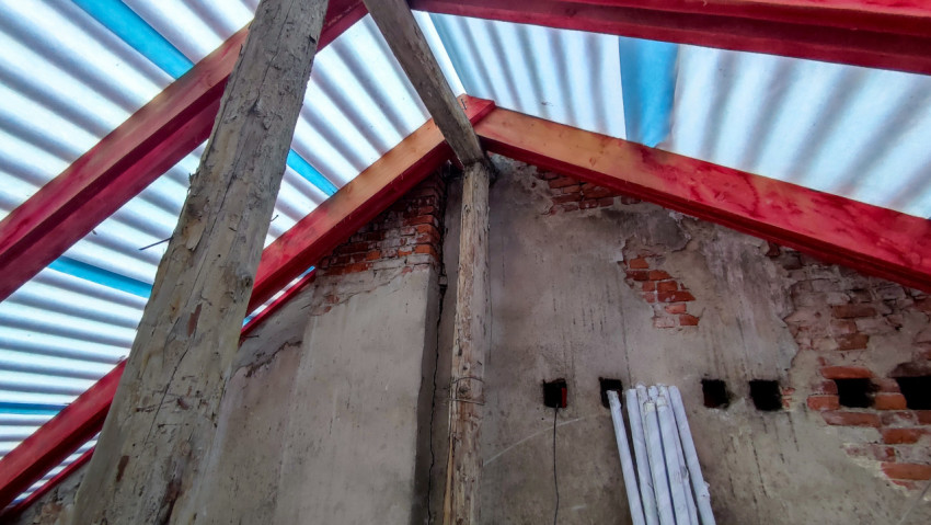 Кирпичная стена чердака с опорами и новыми стропилами