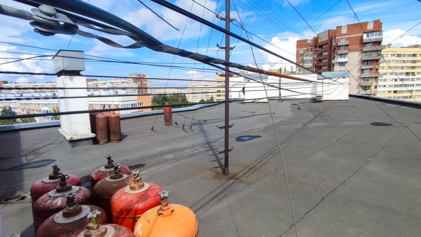 Крыша жилого дома с газовыми баллонами и кабельными линиями