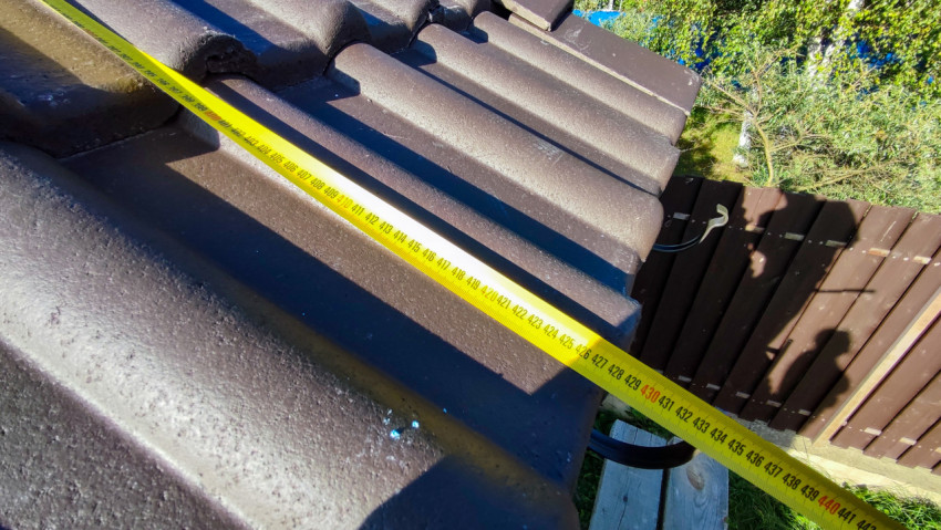 Замер черепичной кровли рулеткой по горизонтали