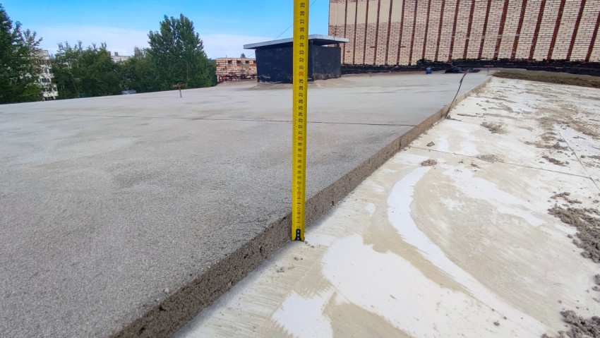 Измерение толщины стяжки на плоской крыше здания