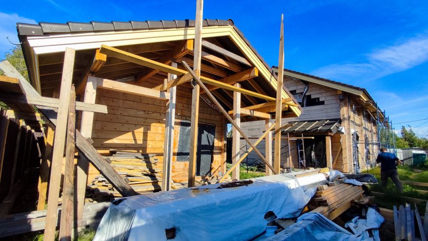 Строящийся деревянный дом с пристройкой и лесами