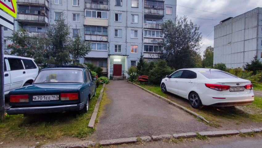 Подъезд панельного дома с припаркованными автомобилями