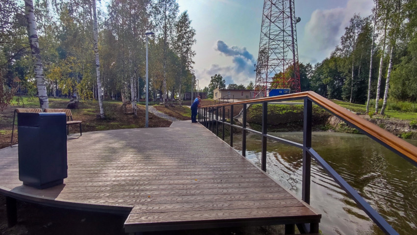 Набережная с деревянным настилом и смотровой площадкой у пруда