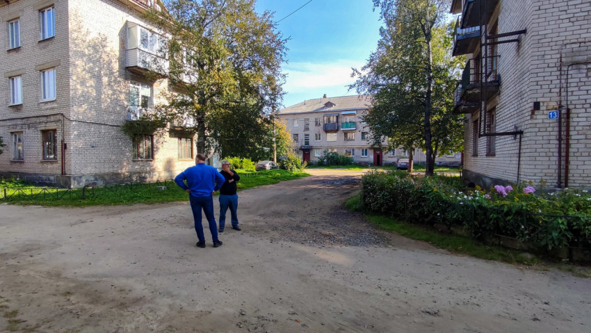 Двое мужчин во дворе жилых домов