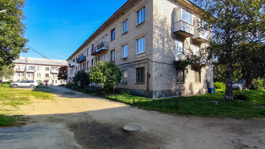 Угол жилого квартала с трёхэтажными домами и грунтовой дорогой