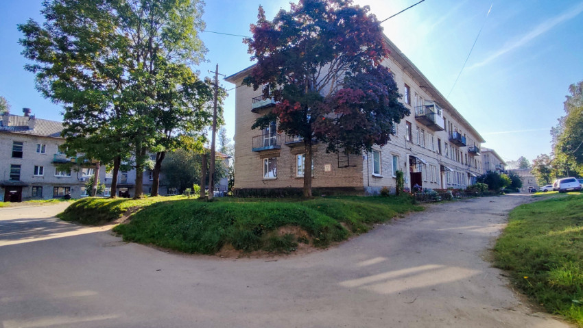 Кирпичный жилой дом советского периода с деревьями во дворе