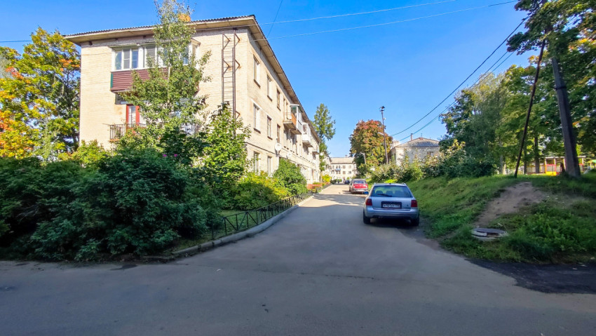 Двор жилого квартала с кирпичными домами и припаркованными автомобилями