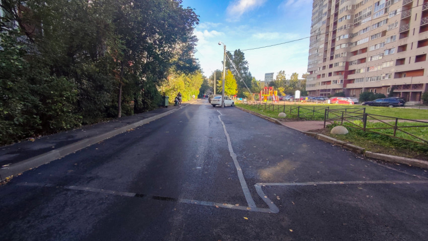 Асфальтированная улица между жилыми домами и детской площадкой