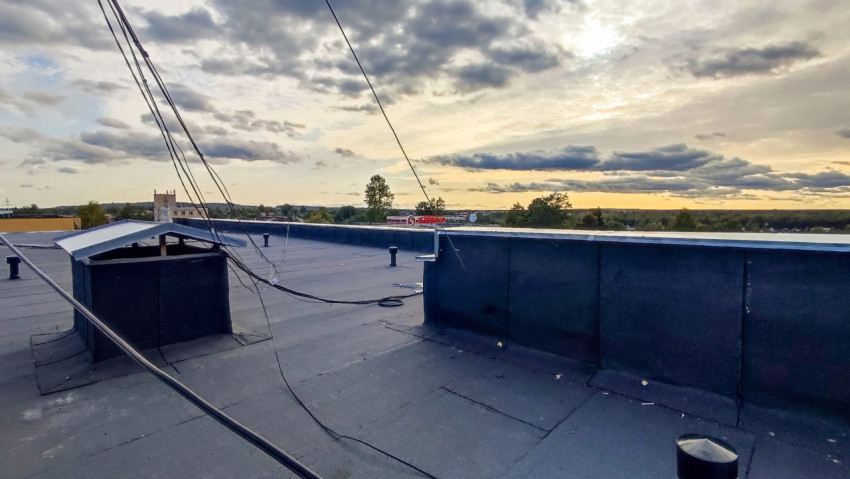 Плоская кровля здания с антенными и электрическими кабелями