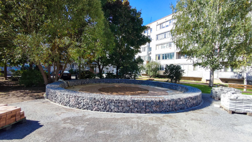 Каменная площадка круглой формы из габионов во дворе