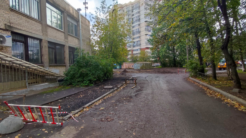 Строительные работы у здания из кирпича во дворе жилого квартала