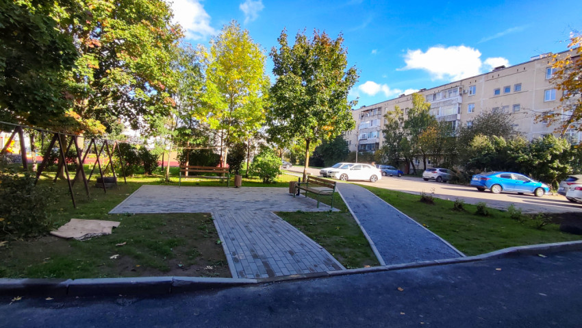 Новая пешеходная зона с лавочками и зелёными насаждениями во дворе жилого дома