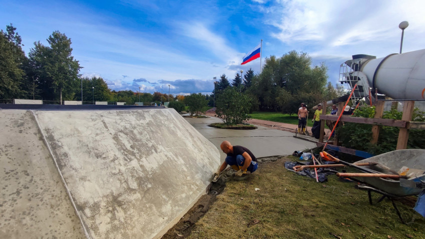Рабочие выравнивают бетонную поверхность в парке