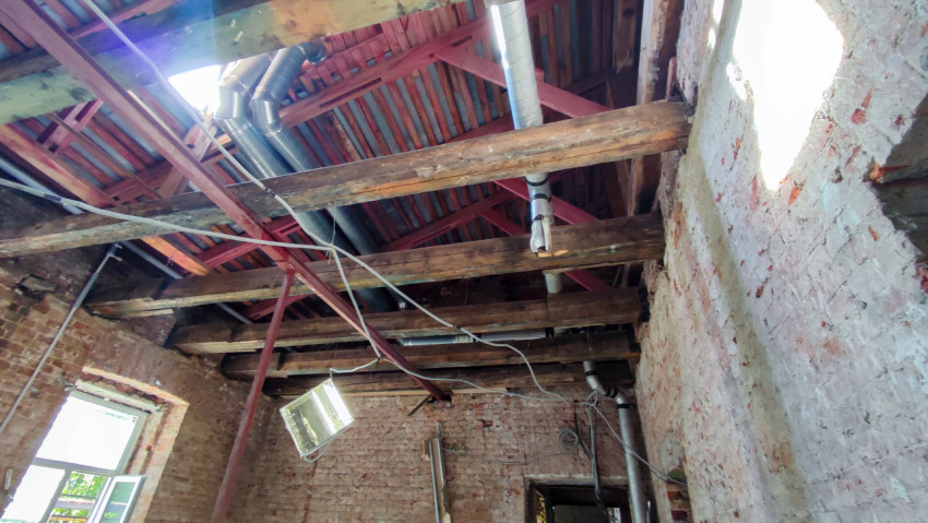 Осмотр деревянных балок и металлических элементов кровли старого здания